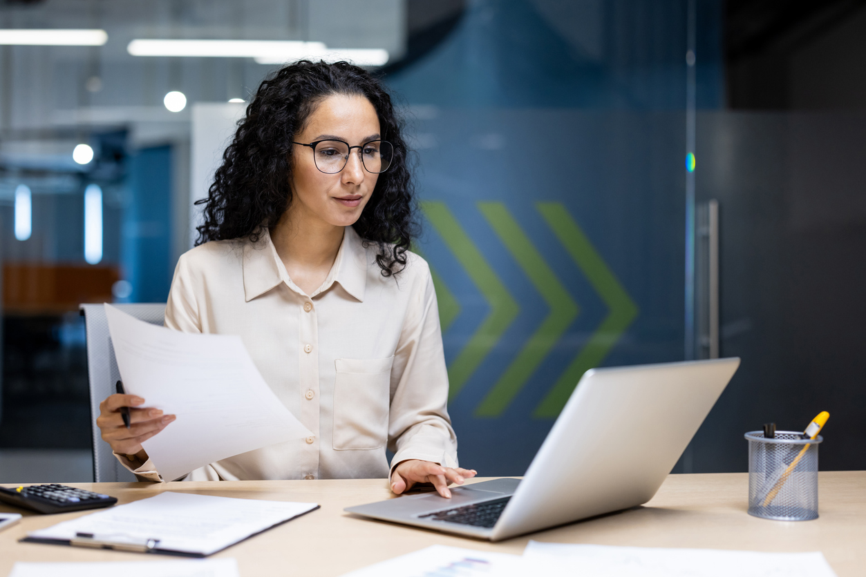 A victimology professional working on a laptop at a desk. 