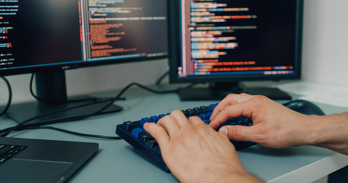 A Cybersecurity Analyst Types Code on a Desktop Computer..jpg