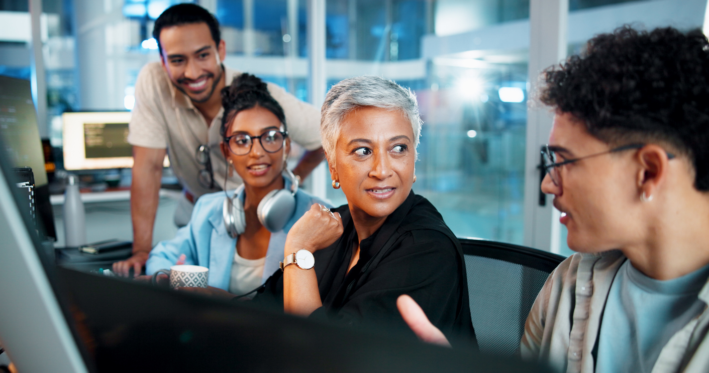 IT professionals collaborating in a room with monitors.