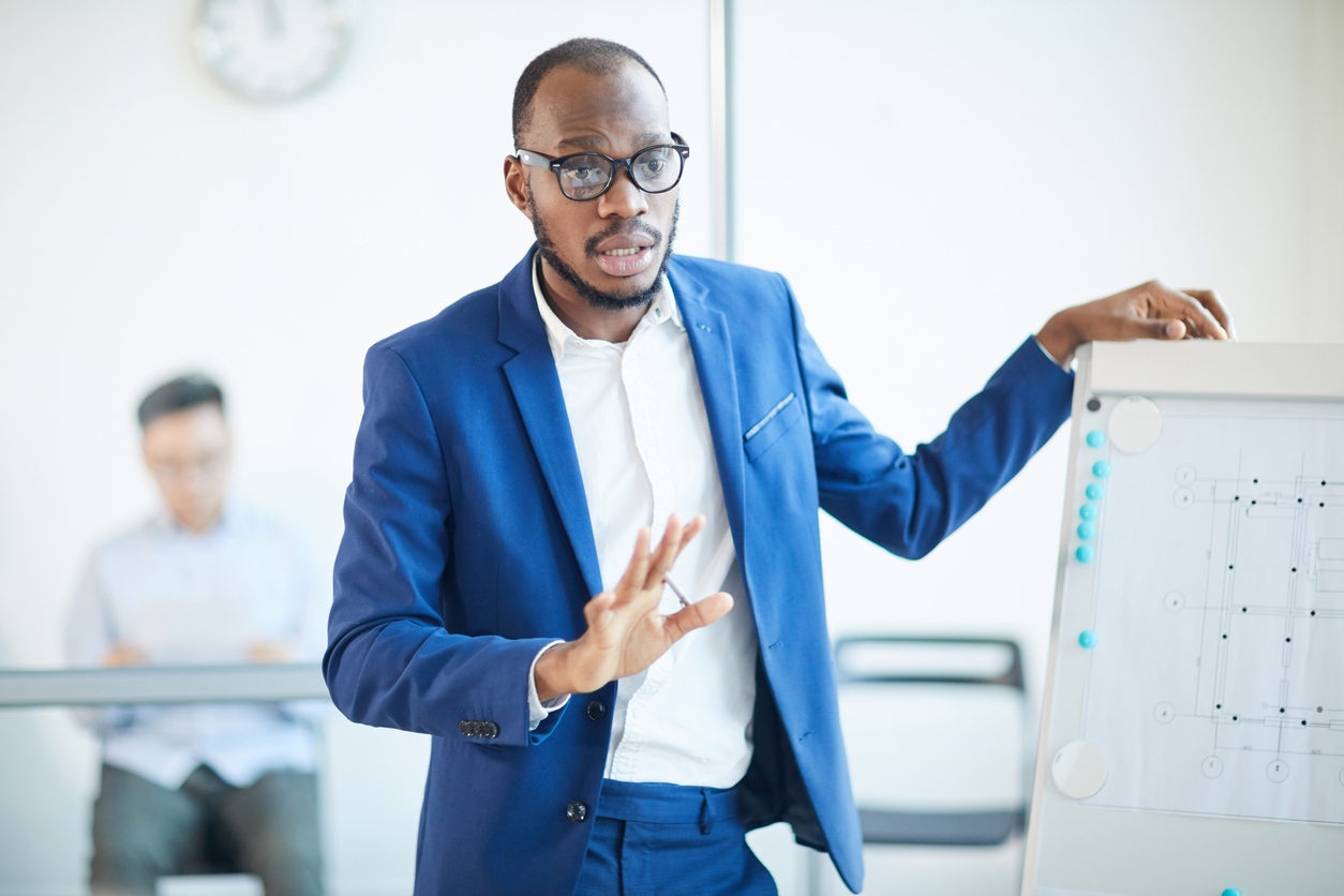 An emergency management director presenting on a whiteboard.