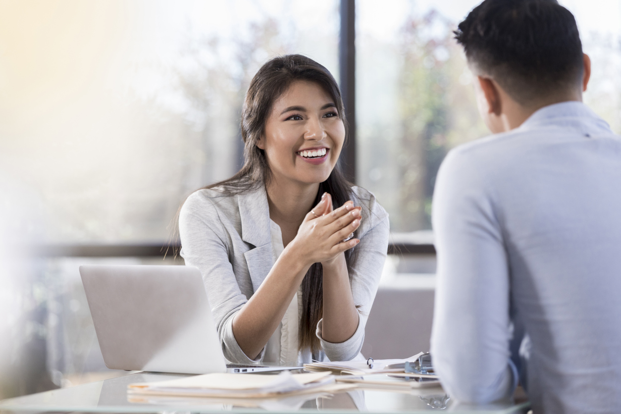 A Professional Smiling in a Meeting With a Colleague.