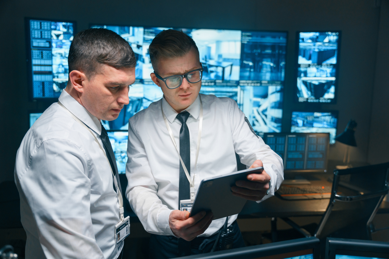 Alt Text Security Studies Graduates Looking at a Tablet.