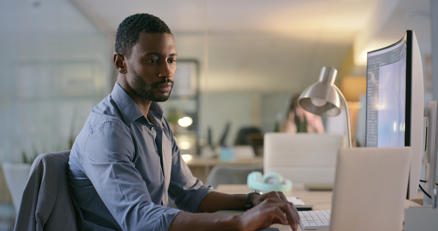 A foreign affairs analyst working on a computer at a desk.