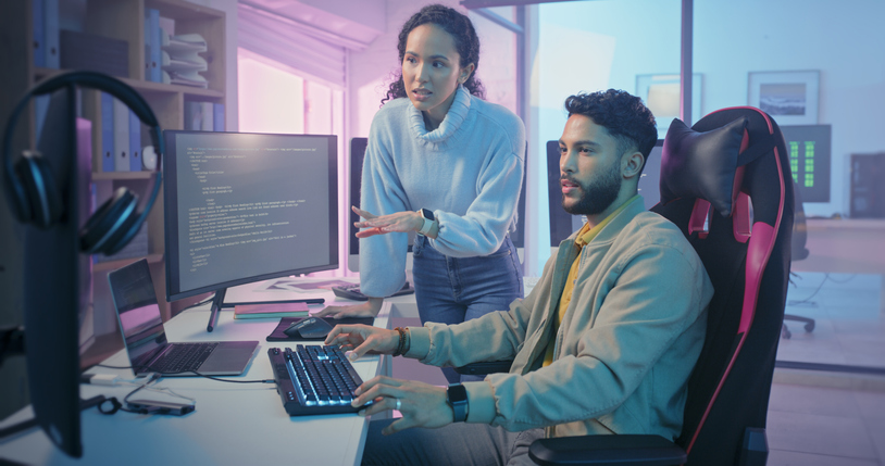 Cybersecurity professionals review code on a monitor.