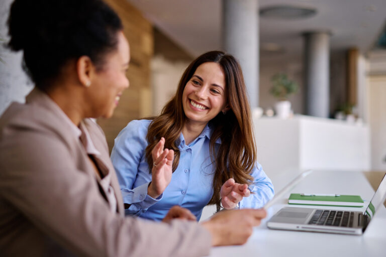 A Professional Smiling and Talking With a Colleague..jpg