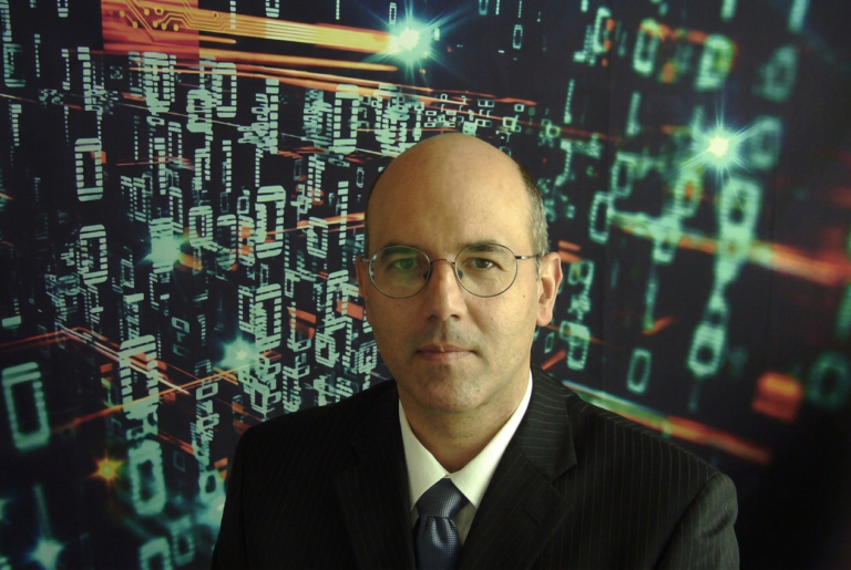 A headshot of Armin Krishnan, PhD, in front of a futuristic, glitchy digital backdrop